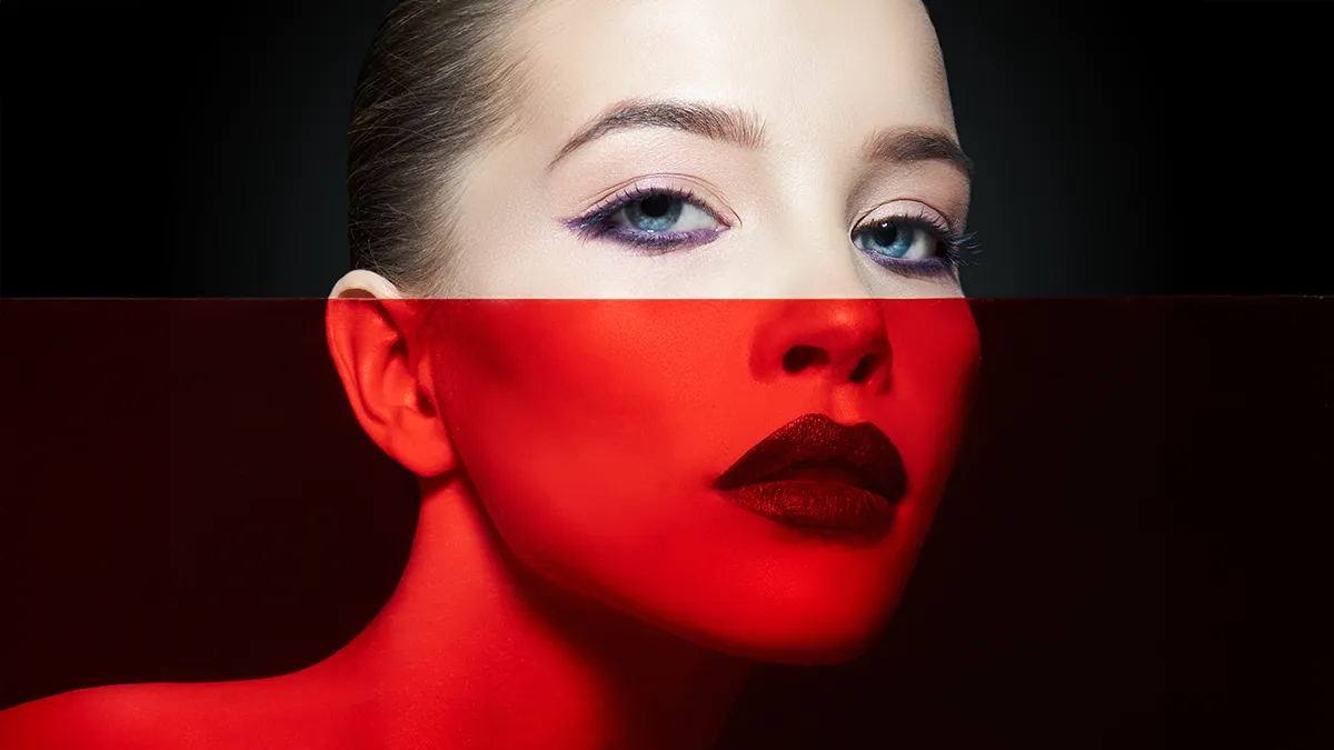 A beauitful woman with red lipstic and half her face red tinted